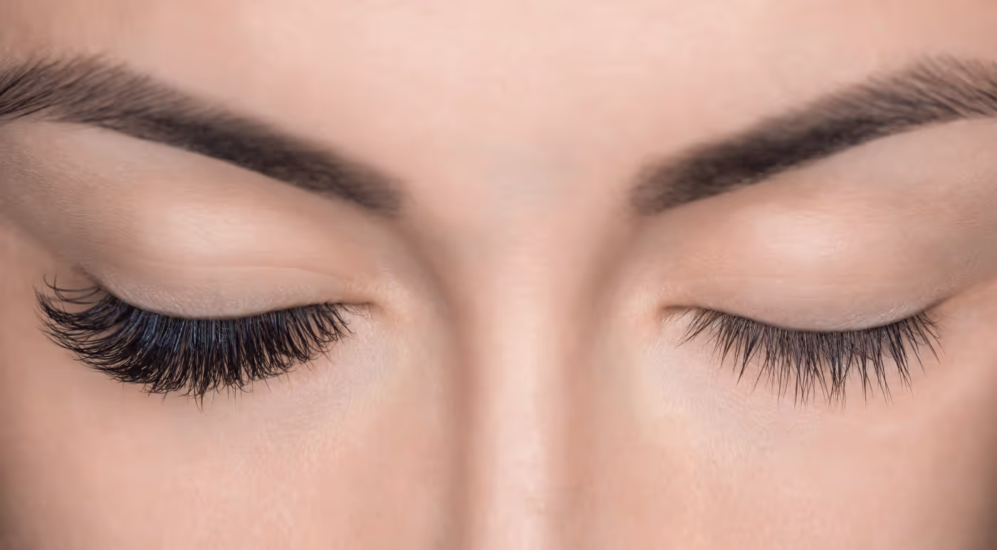 close up of one eye with eyelash extensions and the right eye without